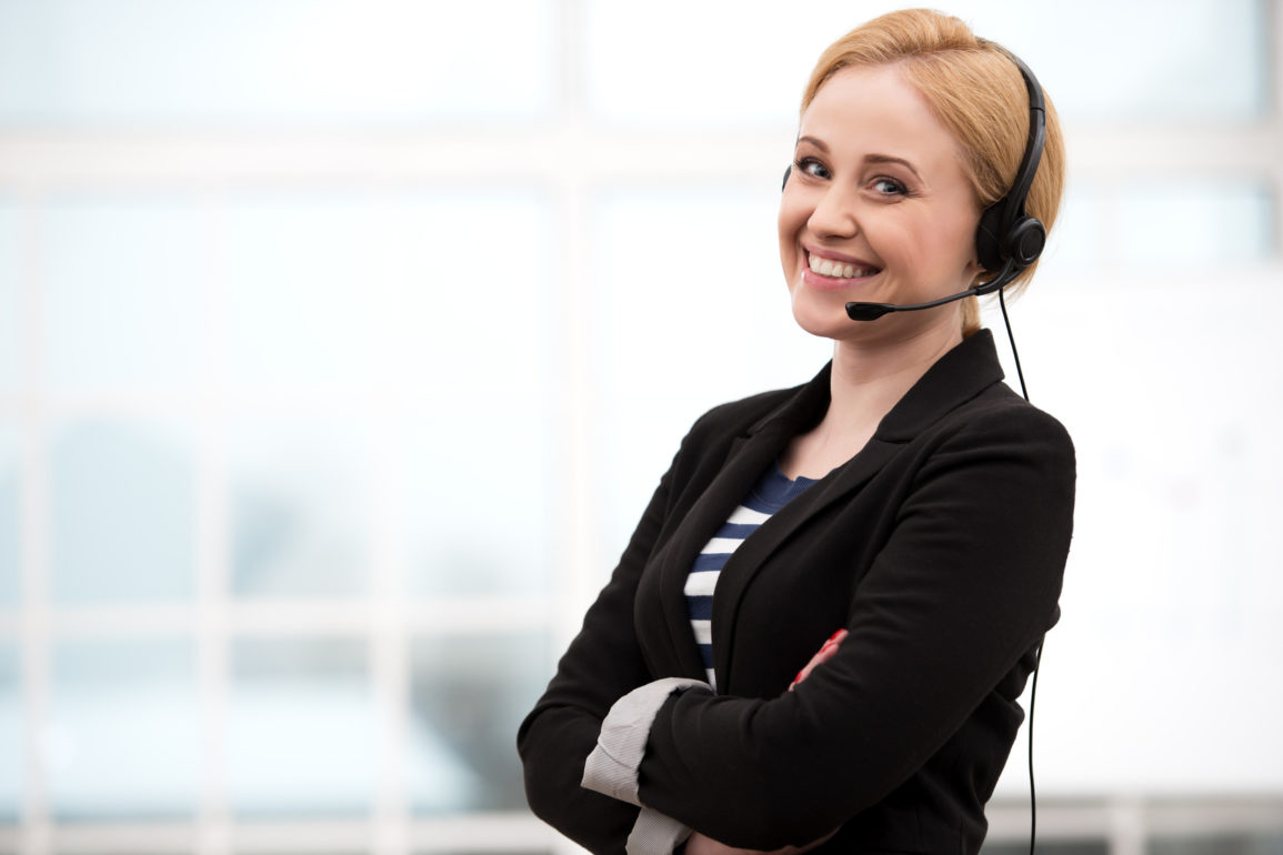 Smiling call center female operator with headphones